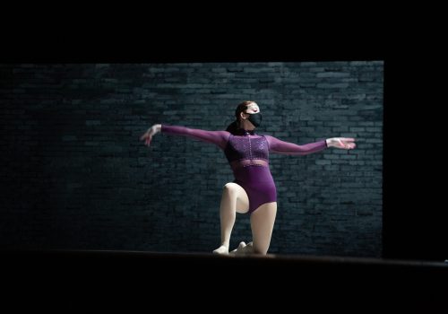 Solo dance performance on a black stage